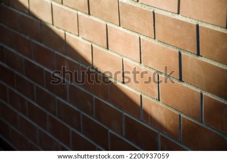 Red brick wall with sunlight pouring down