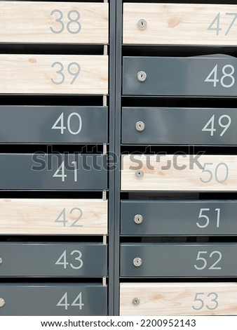 Even rows of numbered mailboxes. Metal mailboxes near the entrance in modern apartment building. Vertical photo