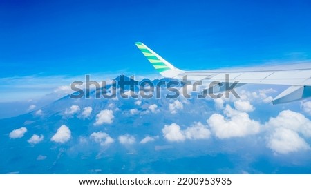 airplane wings over the air against the background of blue sky and mountains