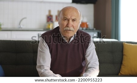 Worried, pensive, 80s old man sitting at home alone, thinking about life alone. Depressed pensive old man with health problems in old age feels lonely. Old age diseases, healthcare concept. Royalty-Free Stock Photo #2200955223