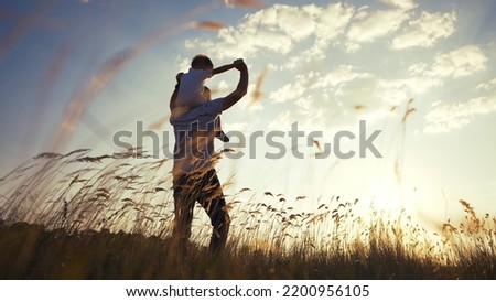 father and son in the park. father's day silhouette happy family child dream concept. father carries his son on his back. dad playing with his son in nature in the park silhouette at sunset lifestyle