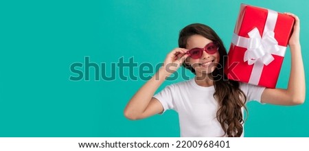 fashionable happy teen girl in sunglasses hold gift box, bday. Kid girl with gift, horizontal poster. Banner header with copy space.