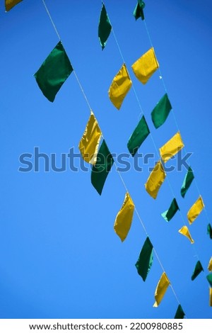 Green and yellow flags in air