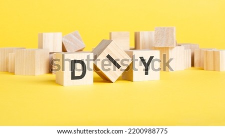 text diy. wooden cubes with letters on yellow background. business concept image.