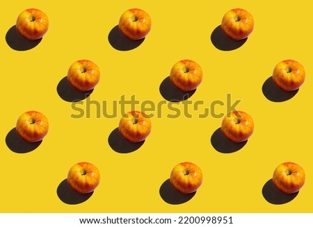 pattern apples on a yellow background with shadows, a repeating picture wallpaper or background on the smartphone screensaver. fruits and vegetables poster for grocery store. a bright background for a