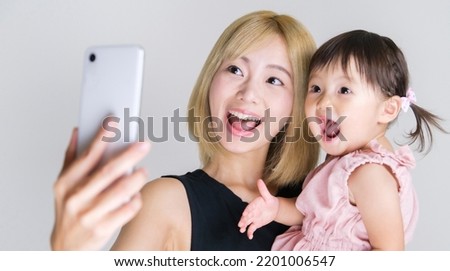 asian baby girl with young mother taking selfie