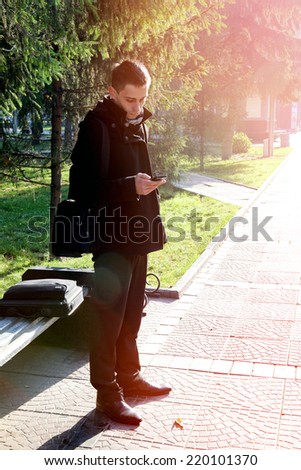 Toned photo of Young Man with Cellphone at the Autumn Park