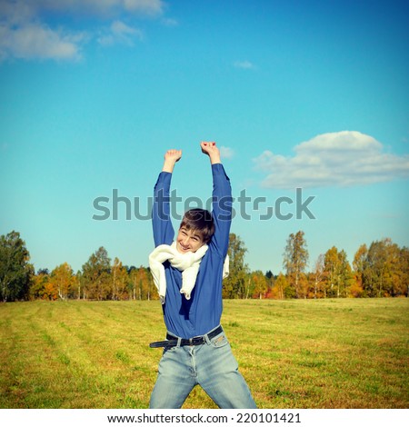 Toned photo of Happy Teenager jumping on the Autumn Field