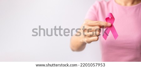Pink October Breast Cancer Awareness month, woman hand hold pink Ribbon and wear shirt for support people life and illness. National cancer survivors month, Mother and World cancer day concept Royalty-Free Stock Photo #2201057953