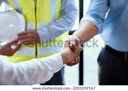 Architect shakes hands at meeting, meeting of two engineers or architects, shaking hands after discussion and meeting of new project plans, contracts for both companies, success, partnership Royalty-Free Stock Photo #2201059167