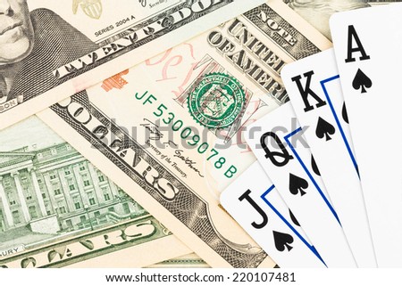 Royal flush poker playing cards on dollar banknote
