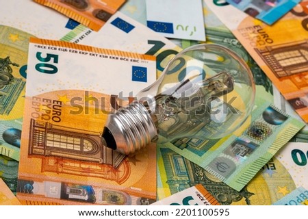 Obsolete uneconomical and unecological bulb on euro banknotes. Increasing of electricity cost for residential customers and business users. 