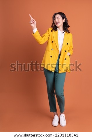 Full length photo of young Asian woman on background