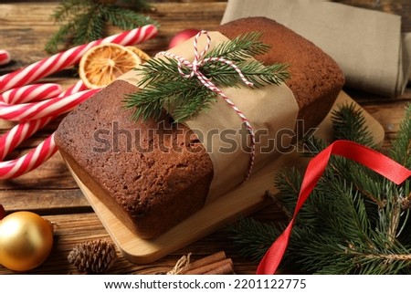 Delicious gingerbread cake, candy canes and Christmas decor on wooden table