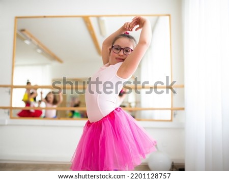 Little girl with down syndrome at ballet class in dance studio. Concept of integration and education of disabled children. Royalty-Free Stock Photo #2201128757