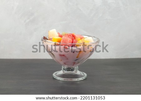 Fruit cocktail with yogurt on grey background. Es Campur or Sop Buah. Popular indonesian fruits cocktail dessert. Selective focus, copy space. Royalty-Free Stock Photo #2201131053