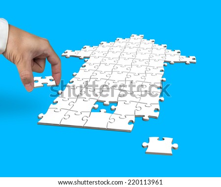 hand with puzzles in arrow shape isolated on blue