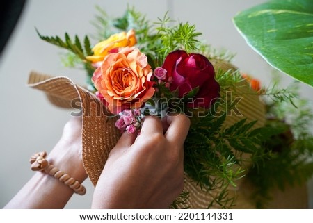Close up photo of arranging flowers on a hat
