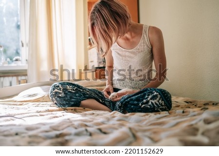 Young woman playing with white rats in her room. Hobby, leisure time.