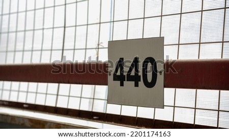 a sign with a parking number is fixed on the wall, taken close up