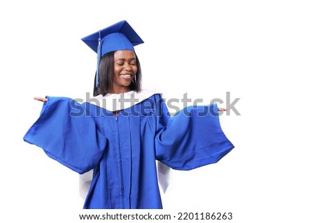 An African-American woman in a blue robe and hat on a white isolated background smiles and spreads her arms with her eyes closed. Mockup for your educational product. High quality photo