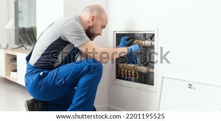 Professional plumber installing plumbing manifolds at home, home improvement and repair concept Royalty-Free Stock Photo #2201195525
