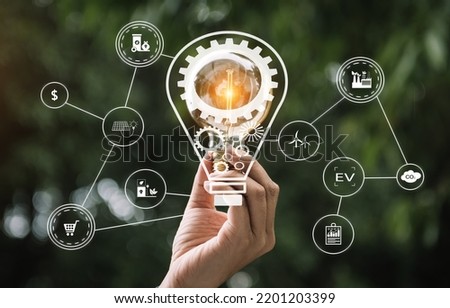 Hand holding light bulb with green background. idea solar energy in nature concept in virtual icon screen Icon

