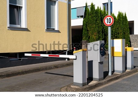 Barrier blocking the road to paid parking. Parking payment system.