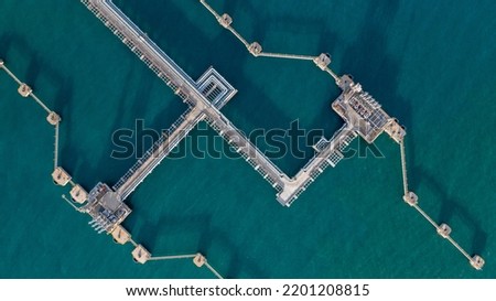 Aerial top view oil terminal station platform with loading arm pipe line on deep seaport, Oil storage terminal port. Royalty-Free Stock Photo #2201208815