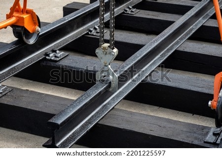 Rail laying equipment. Equipment for creation of railway infrastructure. Moving rail with trolley. Rail crab for installation of railway. Gantry railroad trolley. Railway technologies. Royalty-Free Stock Photo #2201225597