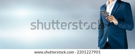 Businessman in blue suit holding credit card with copy space background, Smart technology digital future of business finance and payment online shopping modern concept, Handsome young in close up Royalty-Free Stock Photo #2201227901