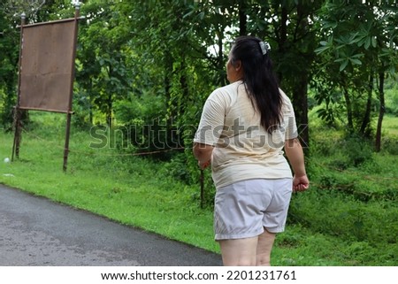 back view fat woman jogging in the park