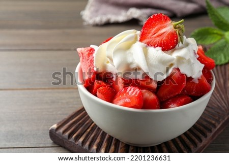 Delicious strawberries with whipped cream served on wooden table, closeup Royalty-Free Stock Photo #2201236631