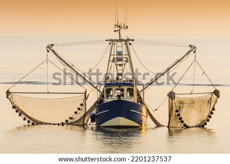Fishing boat on the North Sea fishes with a trawl net, Schleswig-Holstein, Germany Royalty-Free Stock Photo #2201237537