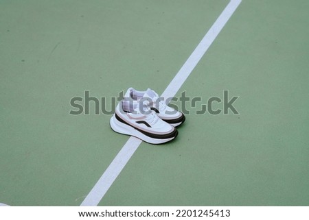Casual sport sneakers in tennis field