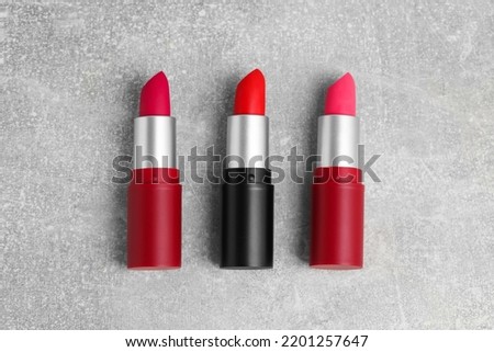 Different lipsticks on grey table, flat lay