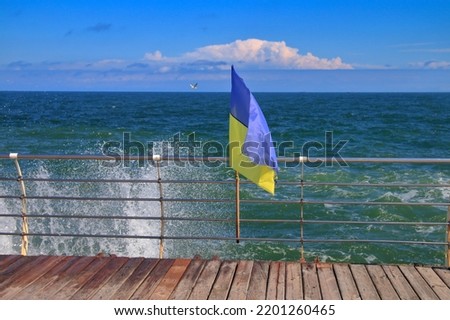 The photo was taken on the coast of the city of Odessa. The picture shows the Ukrainian flag frayed by the wind against the backdrop of a turbulent sea.