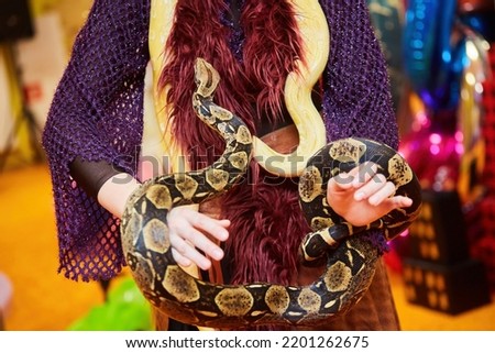 A snake on a man. Exotic animals in the house.