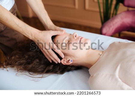skull work of an osteopath massage therapist and receives help Royalty-Free Stock Photo #2201266573
