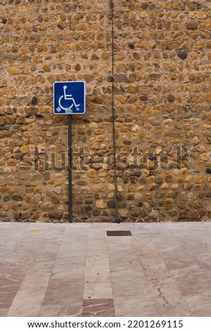 handicapped parking sign, rock wall