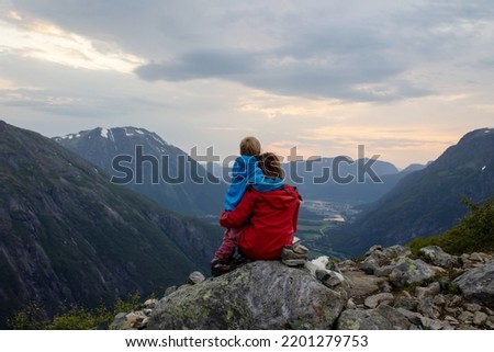 Family with children and dog, hiking in Litlefjellet on sunset, enjoying amazing view from the top of hiking trail Romsdalen Royalty-Free Stock Photo #2201279753