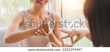 Young attractive Asian women using sign hand finger language conversation with deaf person. Cheerful happy using nonverbal communication to persons with disabilities. Royalty-Free Stock Photo #2201294447