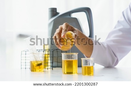 Close up lap worker test and pours car engine oil quality test, checking and compare color difference. Royalty-Free Stock Photo #2201300287