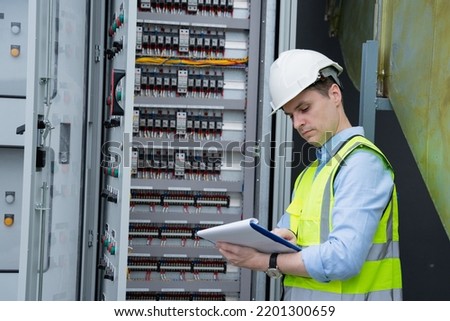 A team of experts checked the operating voltage range while inspecting the electrical switchboard. Royalty-Free Stock Photo #2201300659