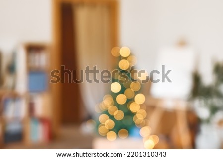 Defocused Christmas tree with lights in festive living room blurred view. Blurred holiday background.