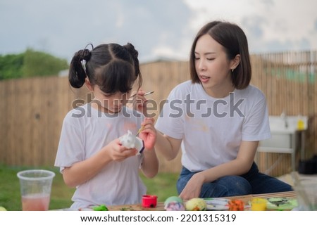 mother and daughter studying art draw a doll