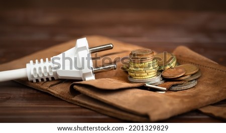 Electrical plug with a wallet and euro money coins. Saving energy, electricity, save power or energy crisis banner. Royalty-Free Stock Photo #2201329829