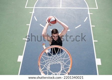 Basketball player. Sports and basketball. Man jumps and throws a ball into the basket.