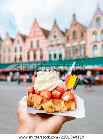 Brugge waffles Belgium, Waffle with cream and strawberry, waffle isolated in hand in Brugge Belgium Royalty-Free Stock Photo #2201348119