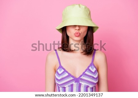 Photo of pretty lovely lady pouted lips kiss panama hat cover eyes isolated on pink color background